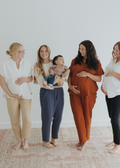 Four women, two pregnant, one holding a baby, wearing Everyday Breeze Pants in cotton gauze.