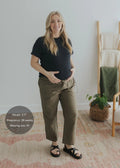 Pregnant woman in olive cotton/linen side drawstring maternity pants and black top.