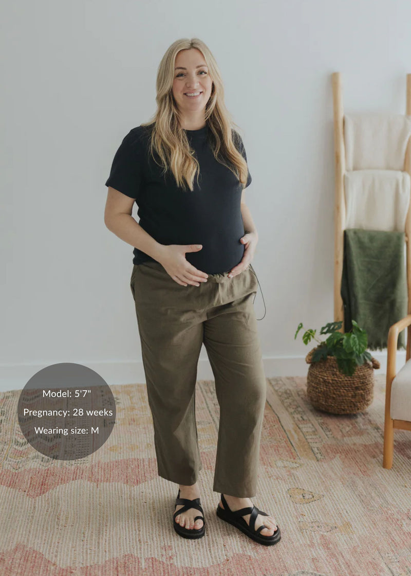 Pregnant woman in olive cotton/linen side drawstring maternity pants and black top.