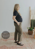Pregnant woman in olive green cotton/linen side drawstring pants with black tee and sandals.