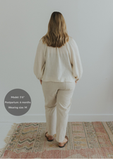 Back view of model wearing Everyday Transitional Smocked Linen Pants in natural beige.
