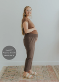 Pregnant woman in brown smocked linen maternity pants with pockets and a matching top.