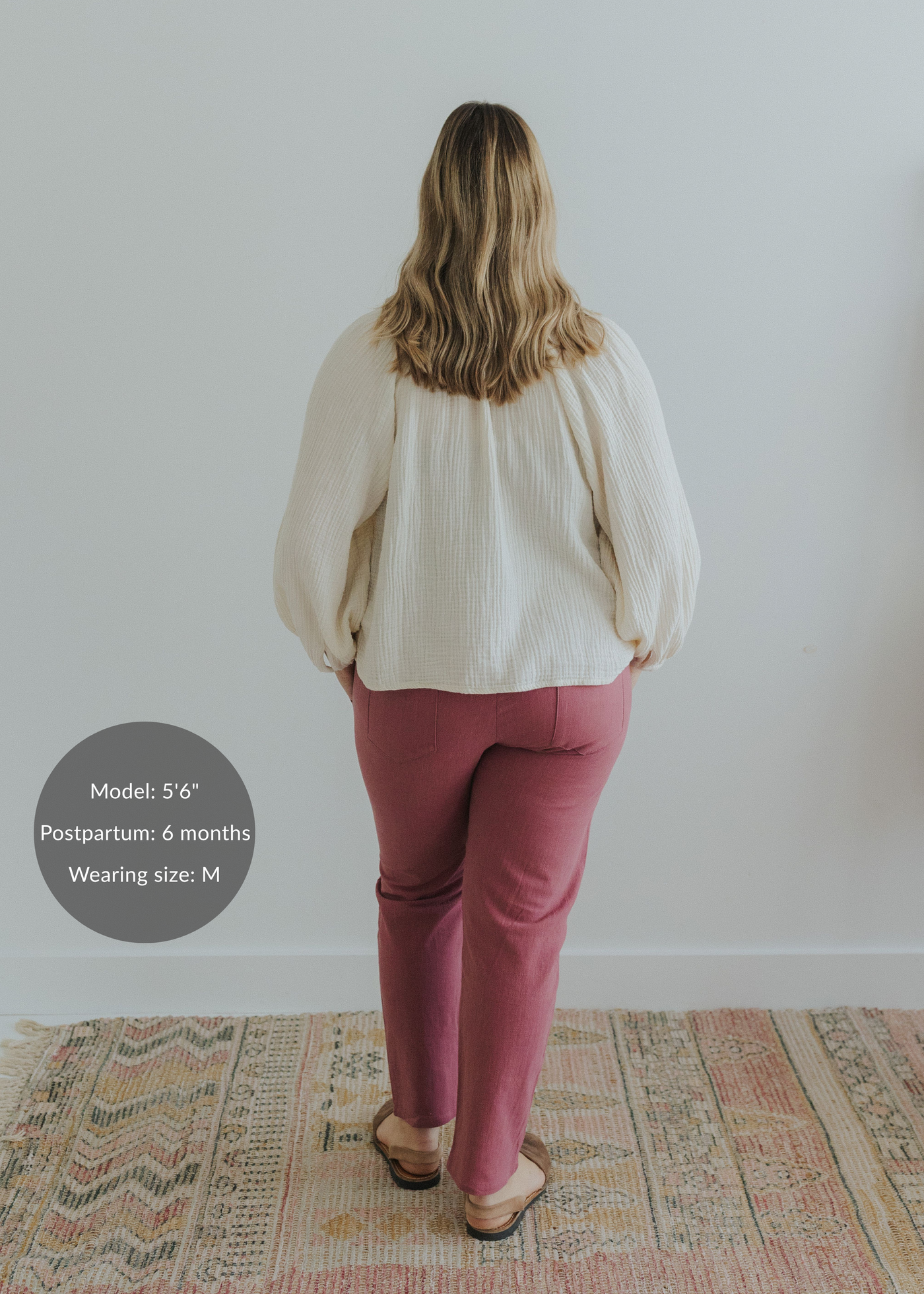 Woman from behind wearing Everyday Transitional Smocked Linen Pants in a deep rose color with an ivory top.