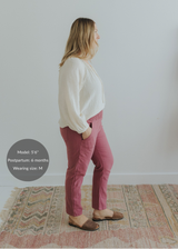 Woman in rose smocked linen maternity pants with pockets and an off-white blouse.