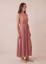 Woman in a rose pink linen-cotton blend adjustable pleated wrap maxi dress with a waist tie.