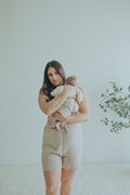 Woman holding her baby in the Sand Crossover Sleep Bra, front view