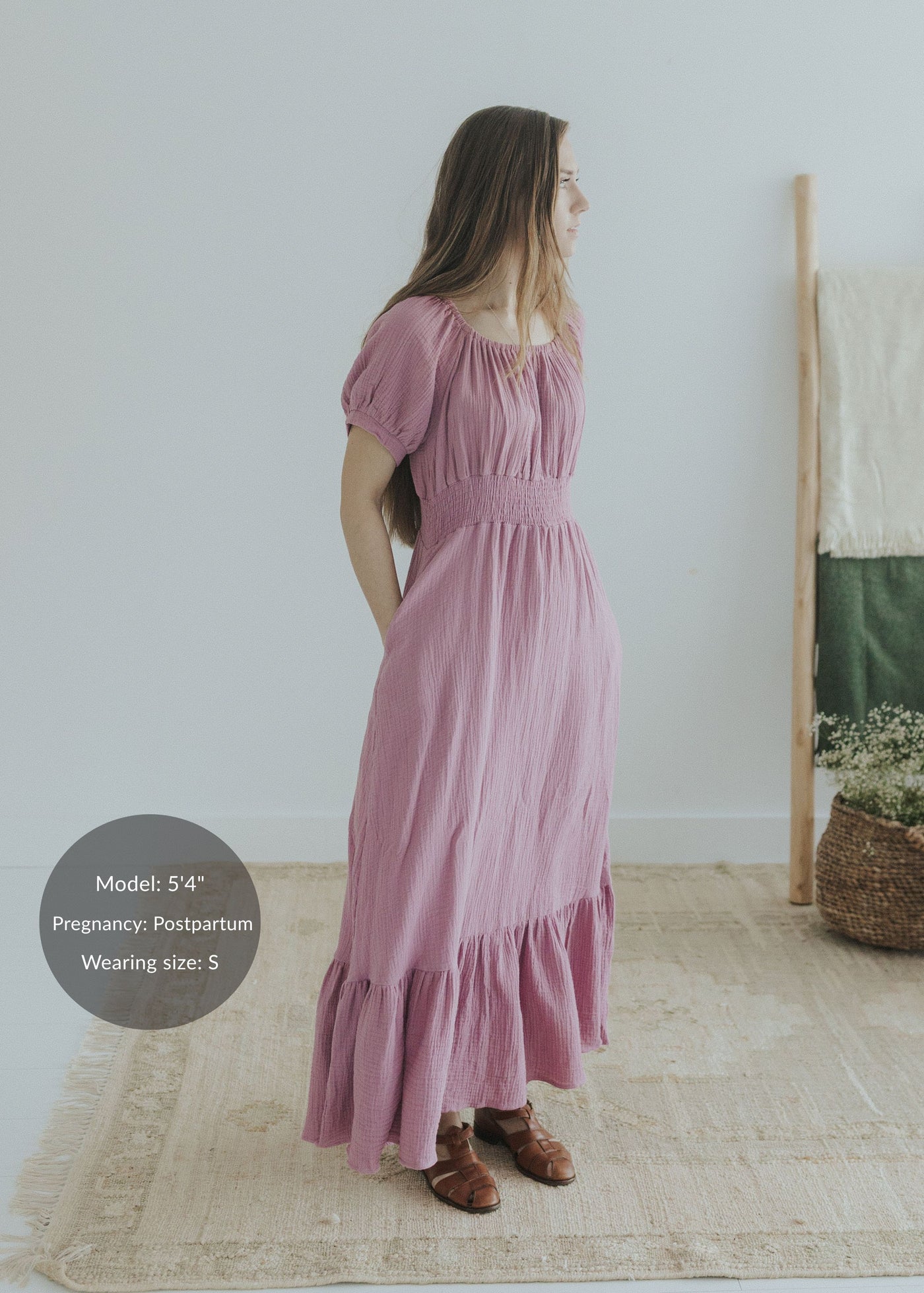 Woman in a mauve organic cotton gauze maxi dress with smocked elastic waist, scoop neck, and short sleeves.