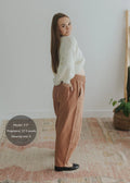 Pregnant model in rust linen-cotton barrel pants with a stretchy waistband and deep pockets.