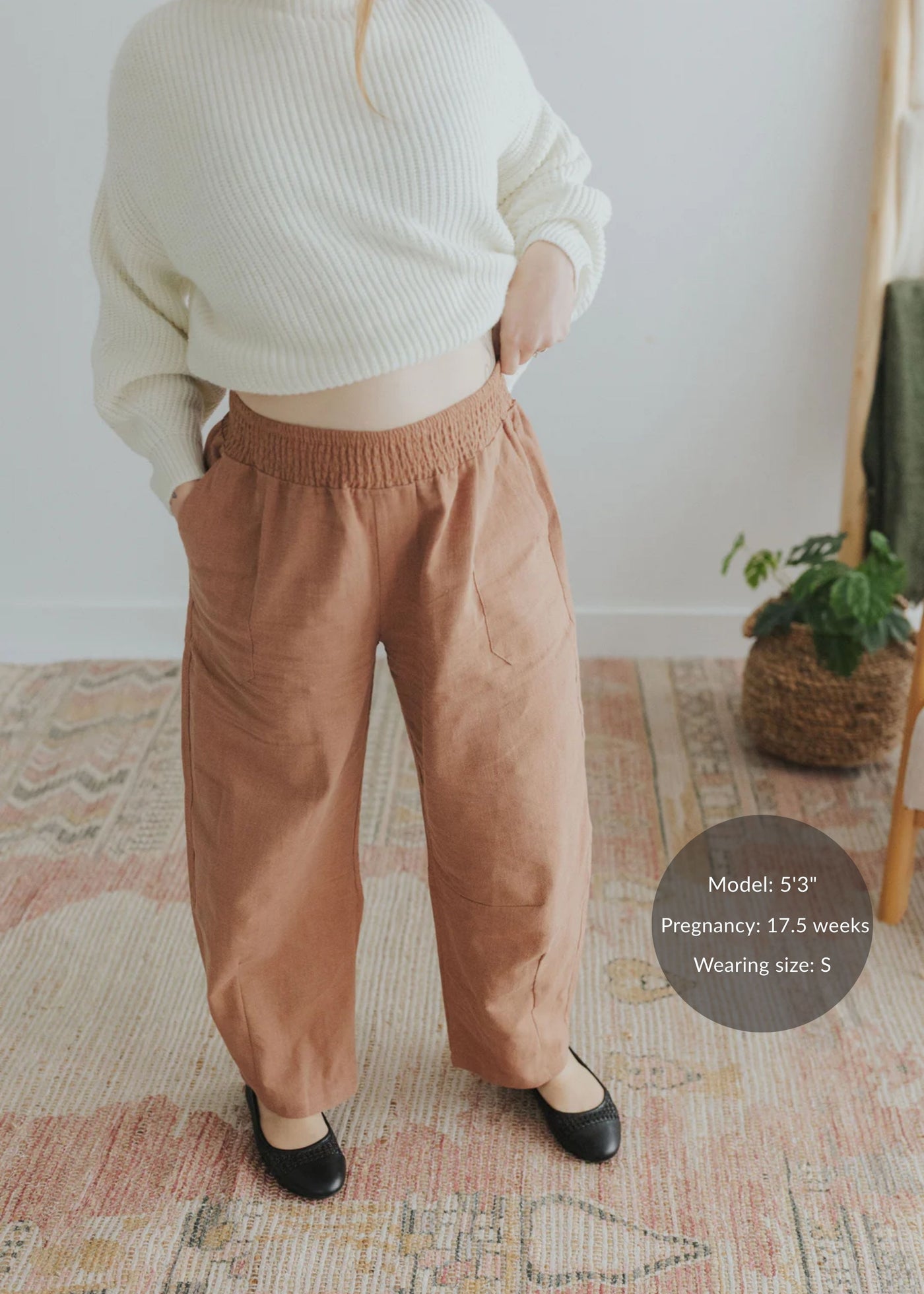 Model in rust linen/cotton barrel pants with elastic waist, deep pockets, and black flats.