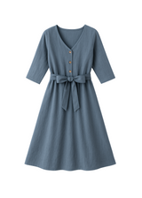 Faye Dress: Blue linen V-neck dress with front buttons, 3/4 sleeves, and a tied waist.