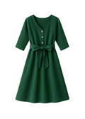 Faye Dress in green softened linen with V-neck, front buttons, 3/4 sleeves, and waist tie.