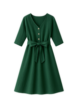 Faye Dress in green softened linen with V-neck, front buttons, 3/4 sleeves, and waist tie.