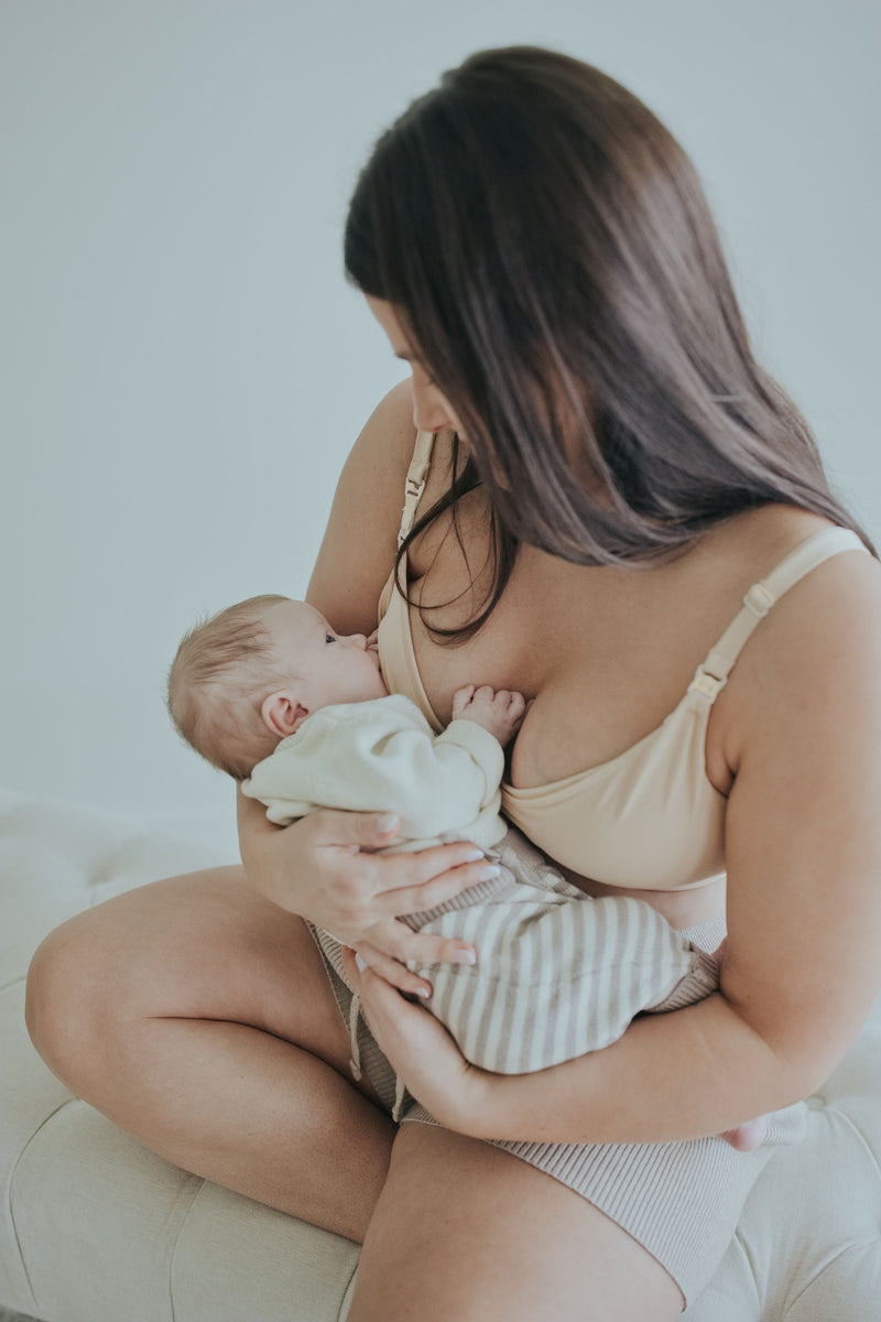 Woman holding her baby in the Beige Front Clasp Nursing Bra