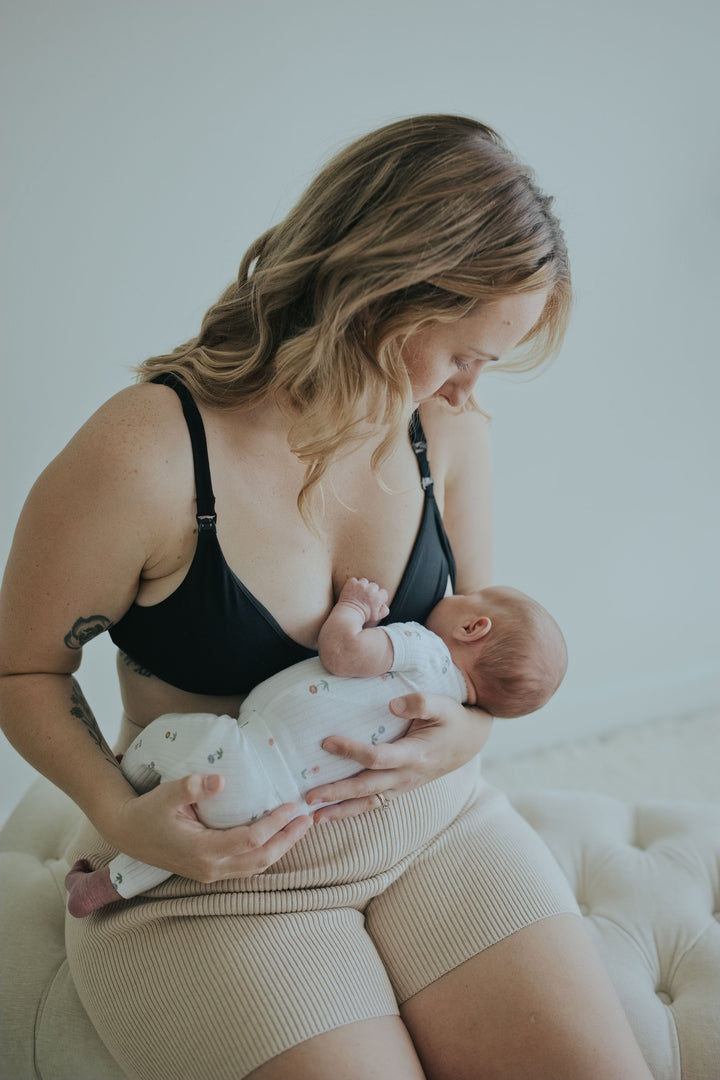 Woman holding her baby in the Ebony Front Clasp Nursing Bra