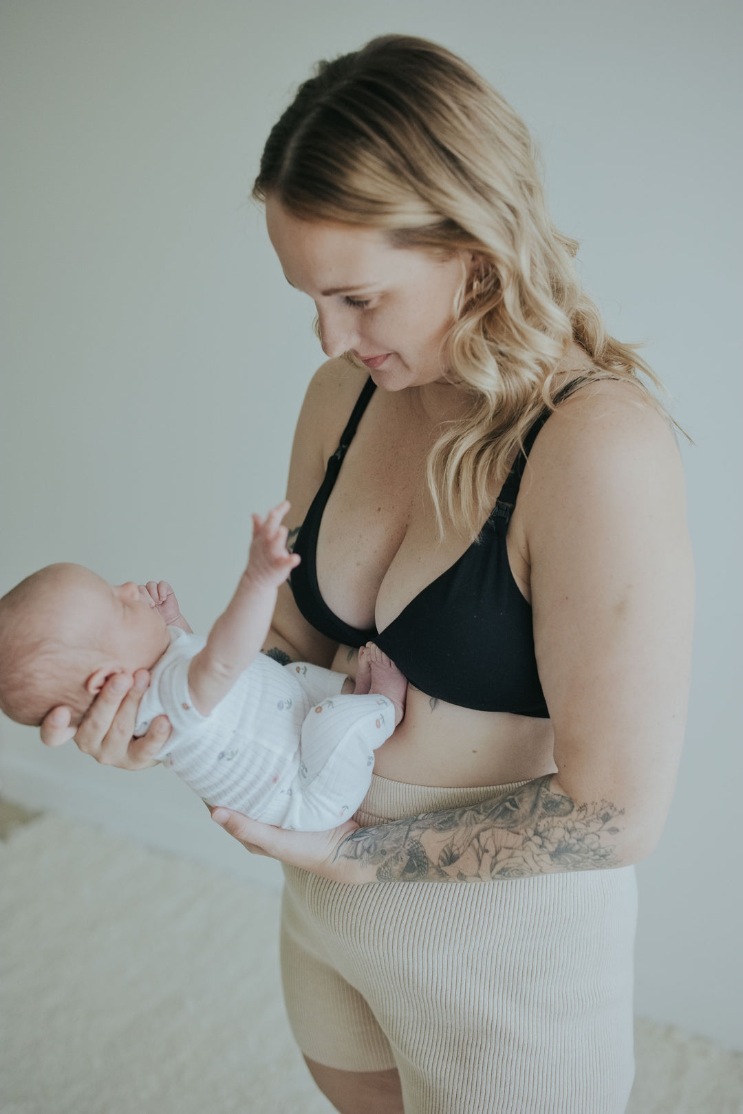 Woman holding her baby in the Ebony Front Clasp Nursing Bra