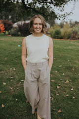 Smiling woman in the Beige Haven Lift Top, front view, tucked into wide leg pants