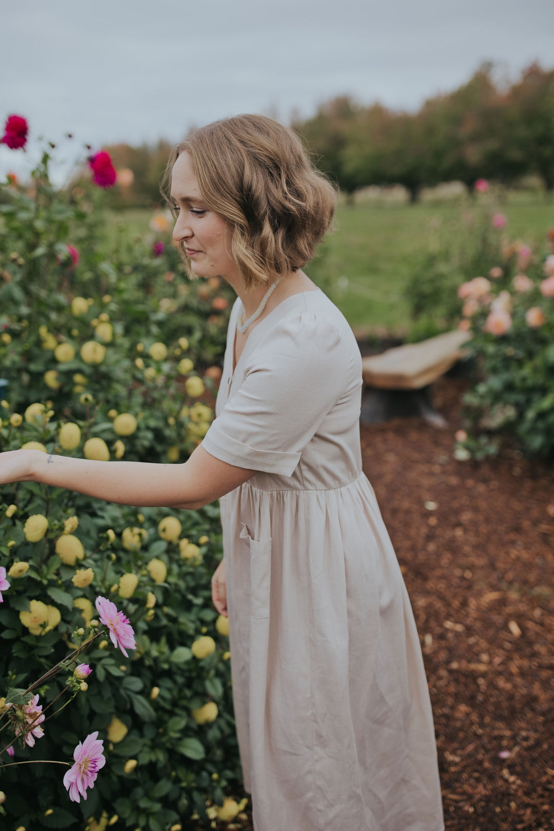 Side profile of the Beige Hazel Front Button Dress with short sleeves and gathered waist