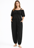 Off-Shoulder Peplum Jumpsuit in Linen in Black — on model