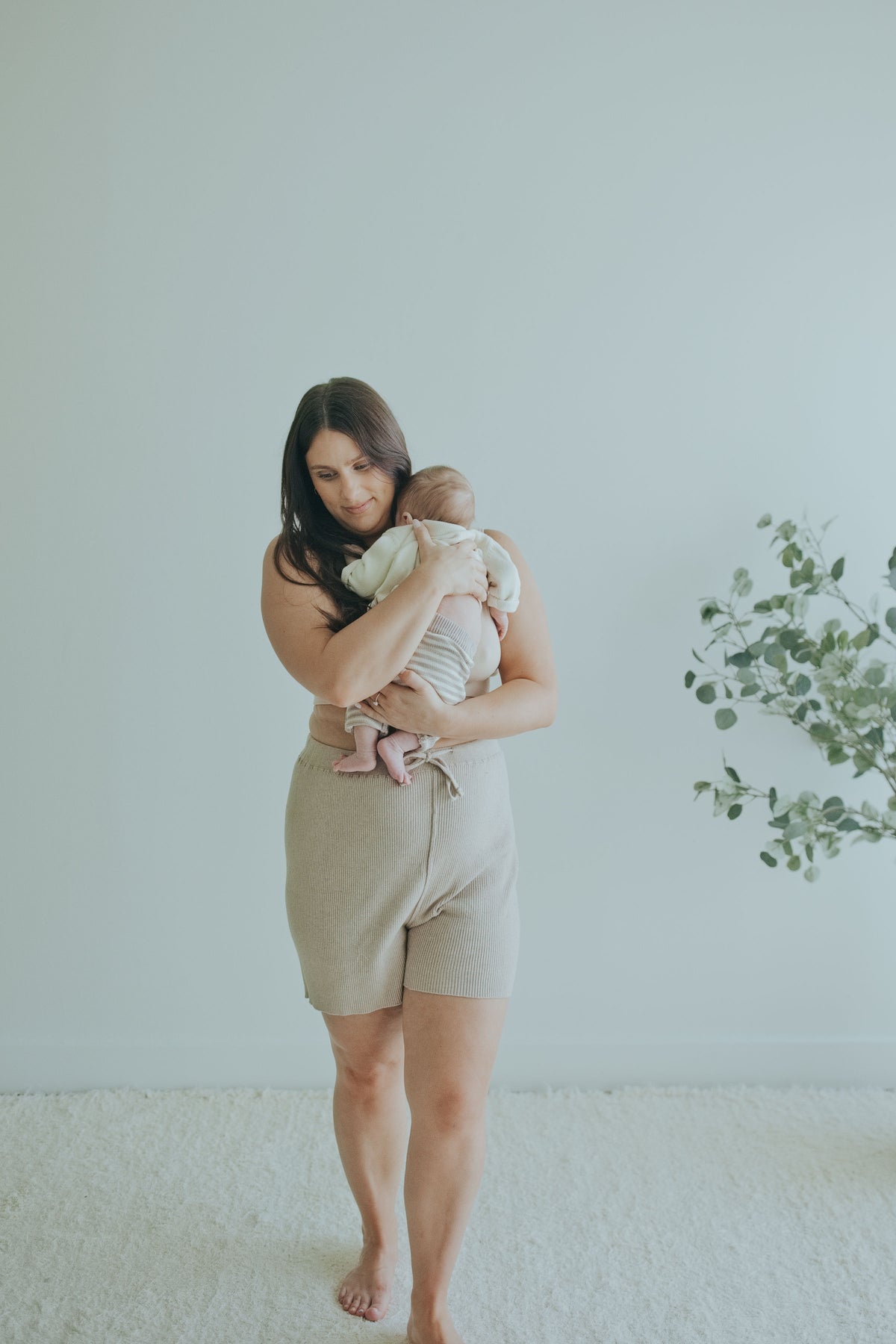 Mother holding her baby in the Mocha Knit Shorts