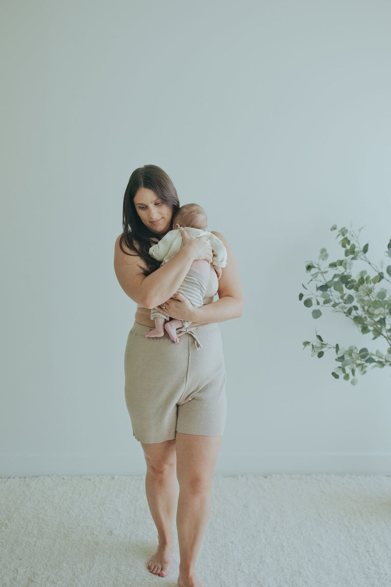 Mother holding her baby in the Mocha Knit Shorts