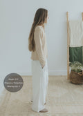 Woman in beige top and white wide-leg cotton/linen flow pants, size S, with hands in pockets.