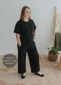 Pregnant woman in a black cotton fleece lounge set with wide-leg pants and a relaxed-fit top.