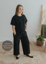 Pregnant woman in a black cotton fleece lounge set with wide-leg pants and a relaxed-fit top.