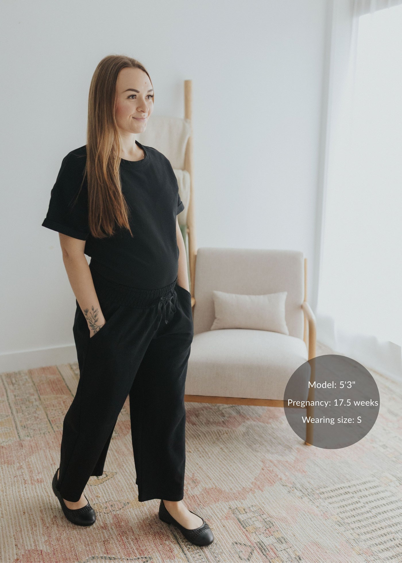 Pregnant woman in a black cotton fleece lounge set with a relaxed top and drawstring pants.