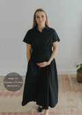 Pregnant woman in a black cotton poplin Sarah Shirt Dress with a relaxed silhouette and smocked waist.