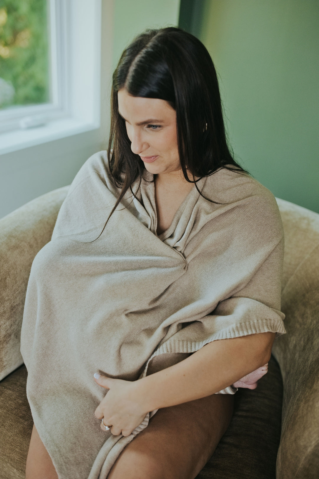 Mother wearing the Mocha Nursing Cover in Cotton Cashmere, seated
