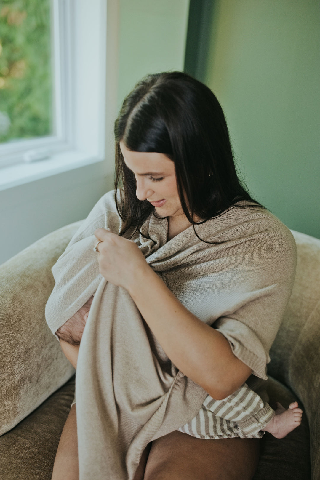 Mother adjusting the Mocha Nursing Cover while nursing