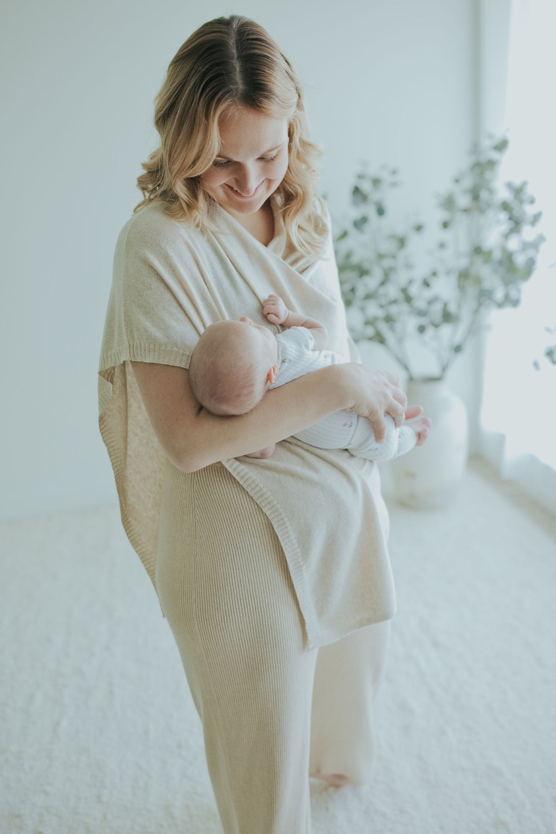 Mother nursing under the Oatmeal Nursing Cover, standing