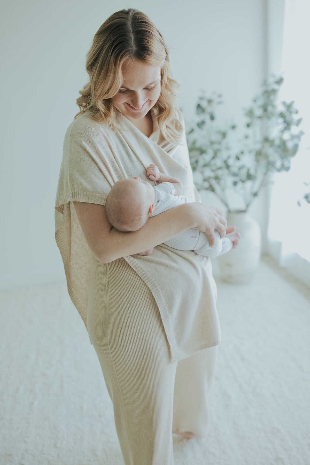 Mother nursing under the Oatmeal Nursing Cover, standing