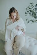 Mother nursing under the Oatmeal Nursing Cover, seated