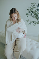 Mother nursing under the Oatmeal Nursing Cover, seated