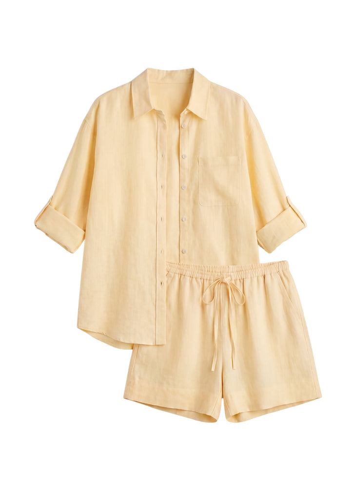 Oversized everyday linen co-ord in light yellow, featuring a relaxed button-up shirt with rolled sleeves and shorts with a drawstring waist.