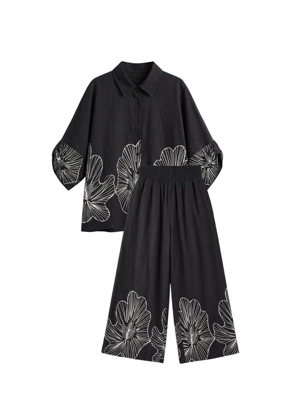 Black oversized cotton smocked set with white floral print, featuring a relaxed shirt and wide-leg pants.