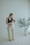 Woman holding her newborn in the Oatmeal Ribbed Knit Wide-Leg Pants, full length front view