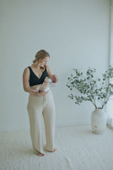 Woman holding her newborn in the Oatmeal Ribbed Knit Wide-Leg Pants, full length front view