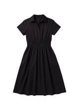 Black cotton poplin Sarah shirt dress with short sleeves, collar, and shirred elastic waist.