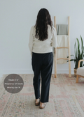 Woman from behind wearing black straight leg cotton/linen maternity trousers and a cream sweater.
