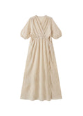 Beige textured crossover maxi dress with puff sleeves, V-neck, and waist tie.