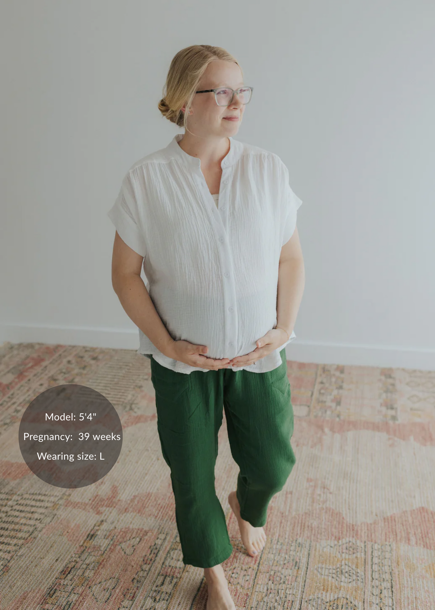 Pregnant woman in a white cotton gauze top and green Everyday Breeze Pant with deep pockets.