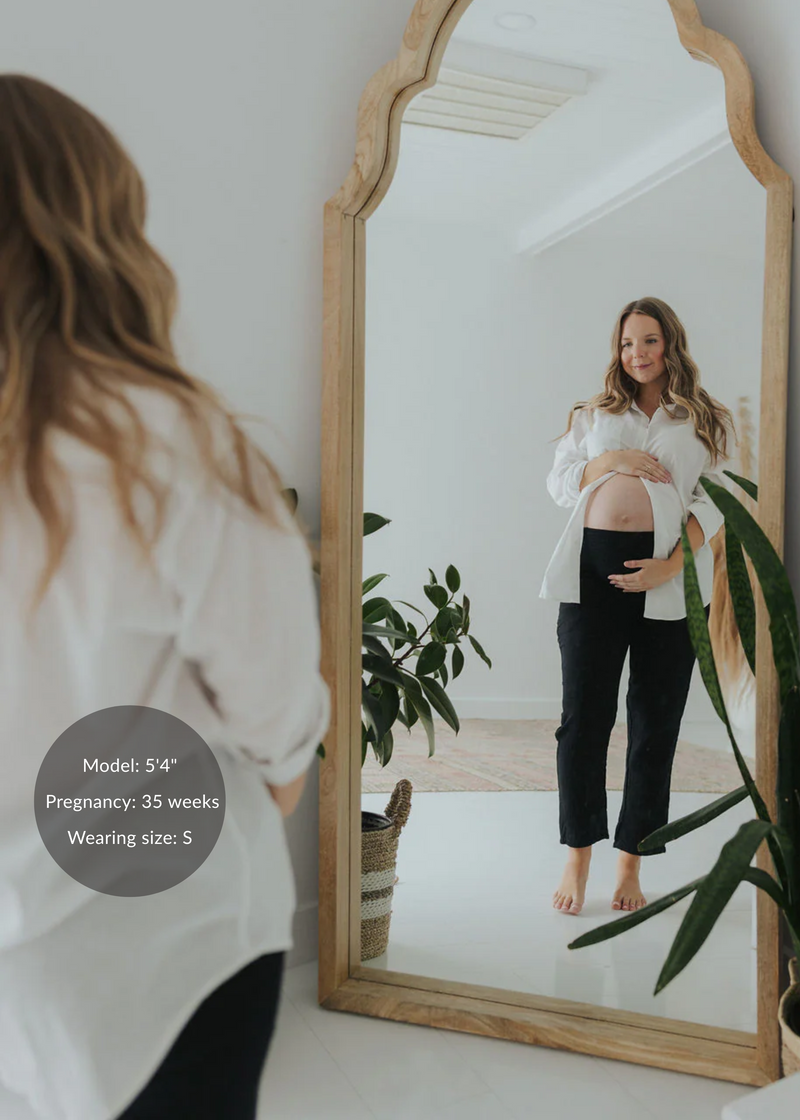 Pregnant woman in black cotton gauze Everyday Breeze Pants with an elastic waistband and deep pockets.