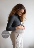 Pregnant model wearing Everyday Transitional Smocked Linen Pants in natural, with a comfortable smocked waistband and pockets.