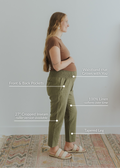 Pregnant woman in olive green smocked linen pants with pockets, tapered leg, and growing waistband.