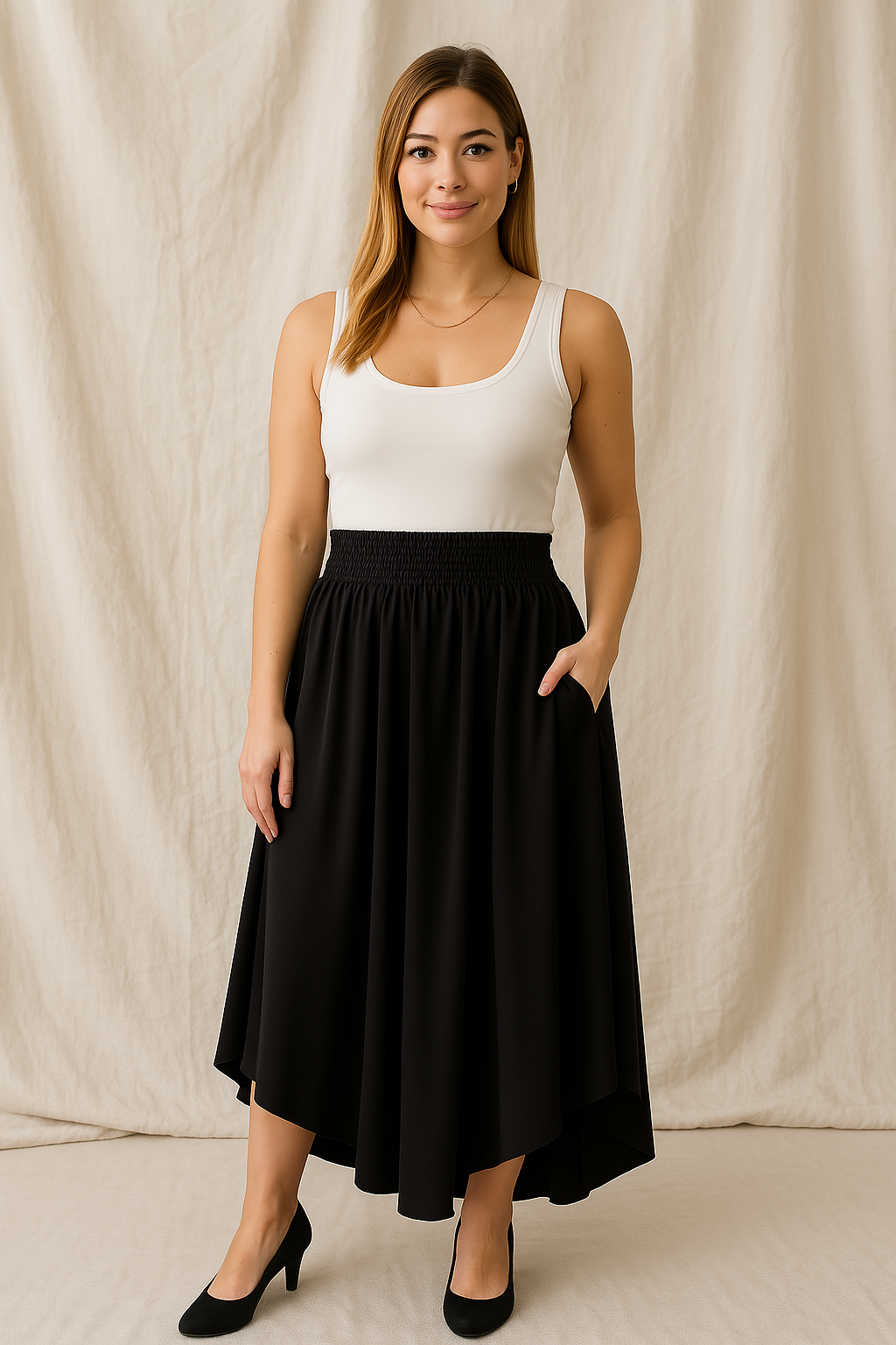 first trimester pregnant woman wearing Transitional Smocked Midi Asymmetrical Skirt posing against a beige fabric backdrop
