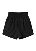 Black smocked cotton/linen blend shorts with deep front pockets and an elastic waistband.