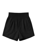 Black smocked cotton/linen blend shorts with deep front pockets and an elastic waistband.