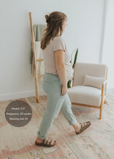 Pregnant model in Everyday Breeze Pant, light green cotton gauze, with elastic waistband and rolled cuffs.